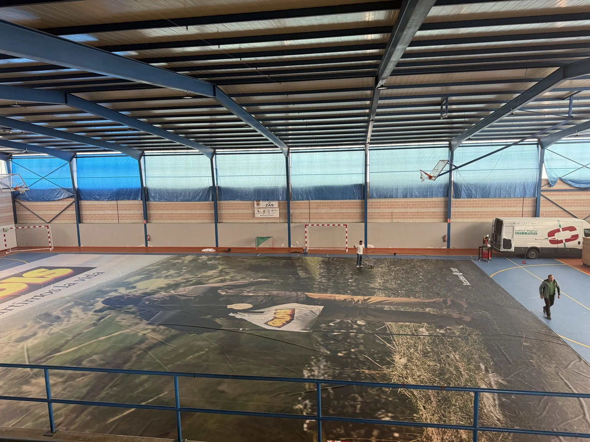 A lona de 700 m² estendida no pavillón, coa furgoneta de Creativa Digital ao fondo